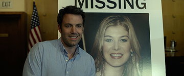 Ben Affleck as Nick Dunne with a photo missing wife Amy (Rosamund Pike) in GONE GIRL
